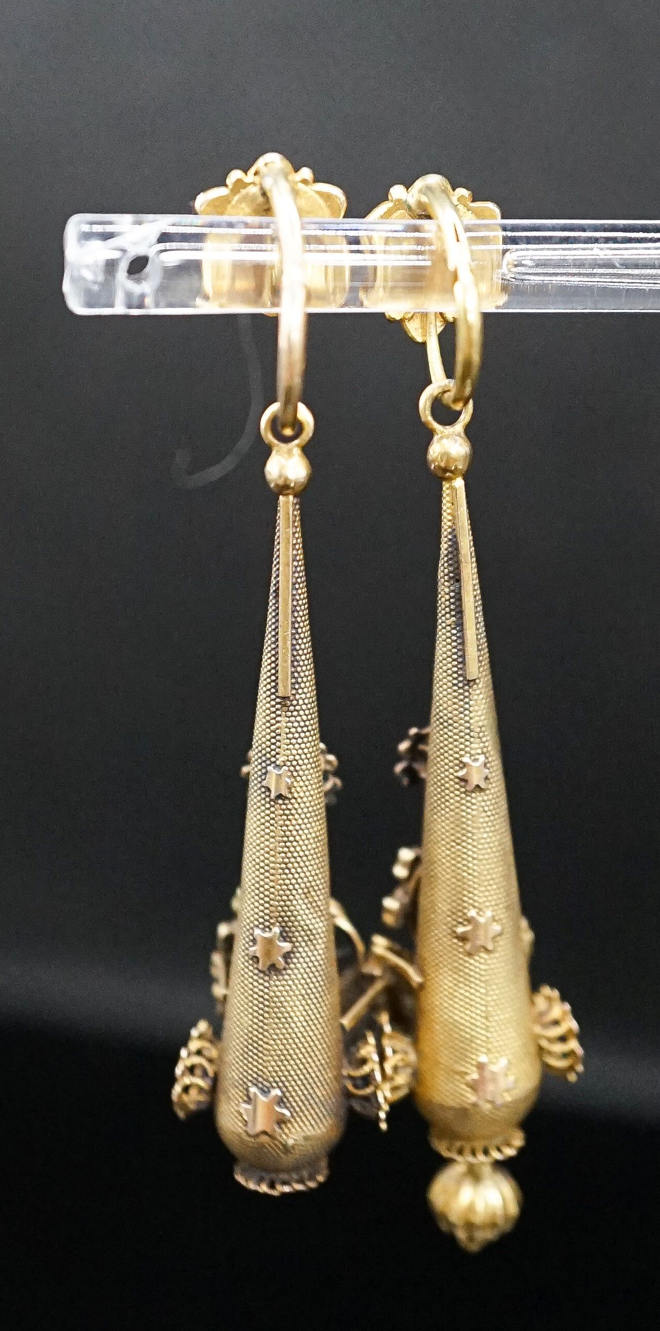A pair of Victorian texture yellow metal pear shaped drop earrings, with star and foliate motifs(a.f.), 45mm, 5.8 grams.